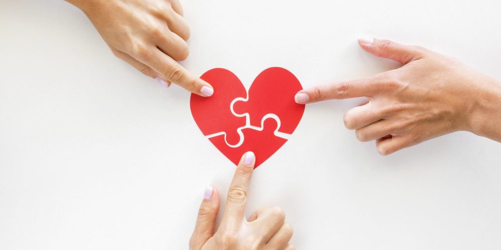 widok-z-gory-rak-dotykajacych-kawalkow-serca-ukladanki